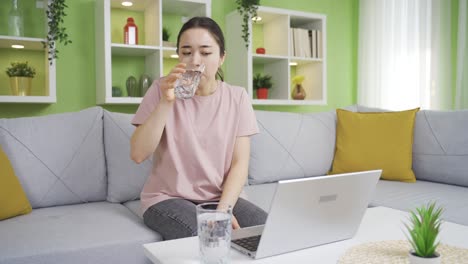 Asian-young-woman-drinking-a-lot-of-water-at-home.